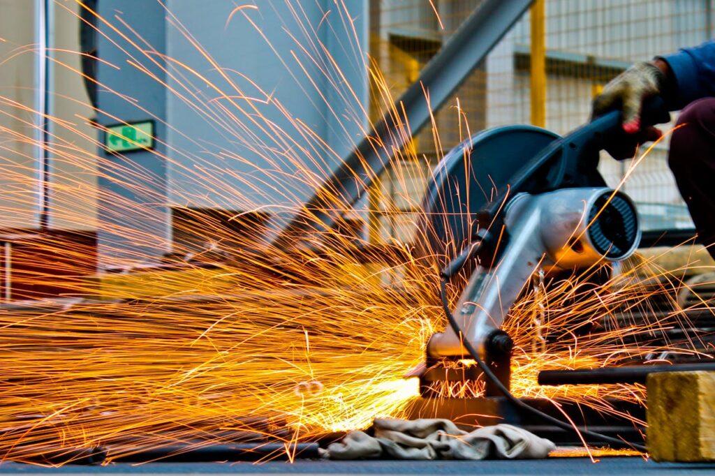 The Art of Drawing Readers In: Your attractive post title goes here A worker operates a grinder cutting metal, creating a vibrant display of sparks in an industrial setting.